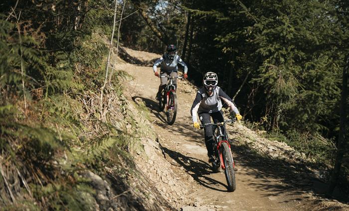 Two women riding down a trail